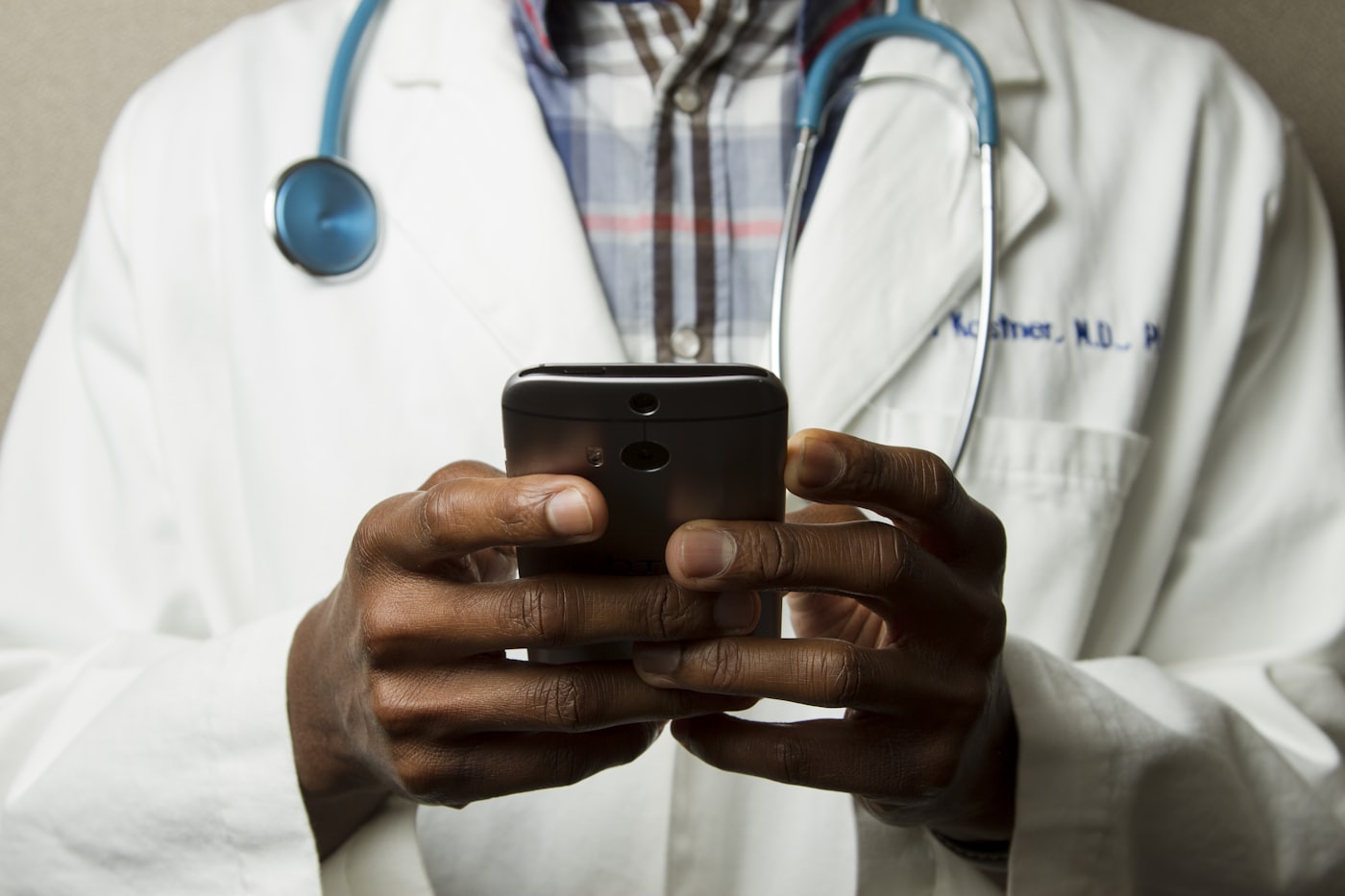 A clinician using a mobile phone — M-Pesa payments built in